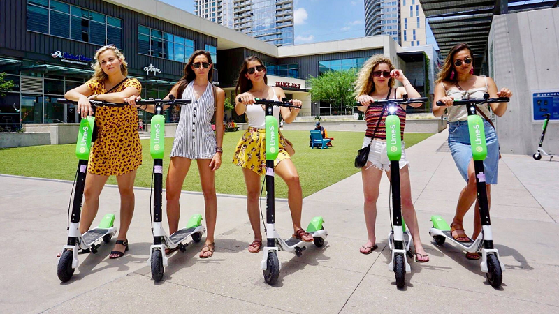 Frauen auf Lime Scootern in der Stadt