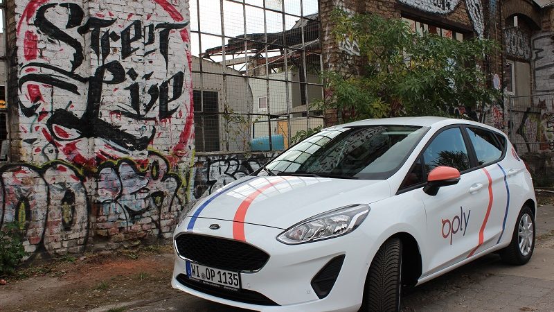 Oply Carsharing Auto vor Mauer mit Graffiti in Berlin