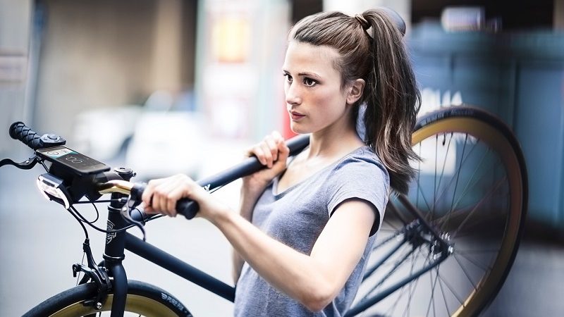 Frau mit Smart Bike in der Stadt