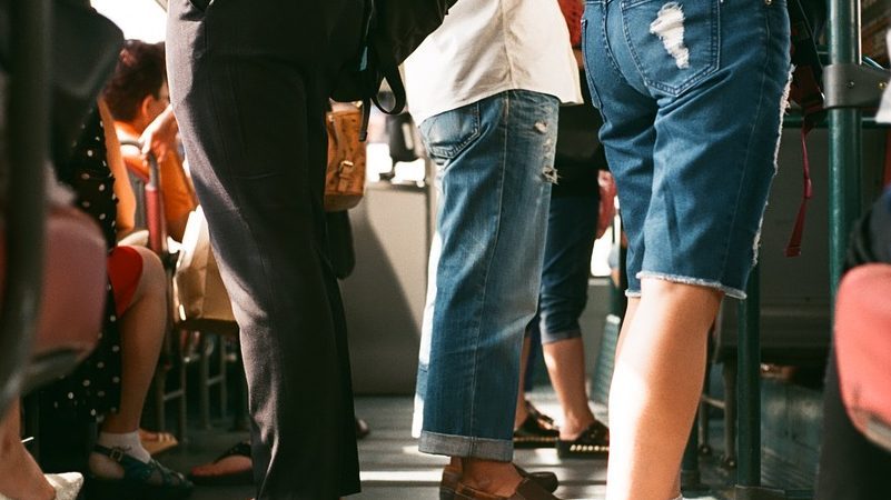 Pendler in öffentlichem Transportmittel Beinansicht