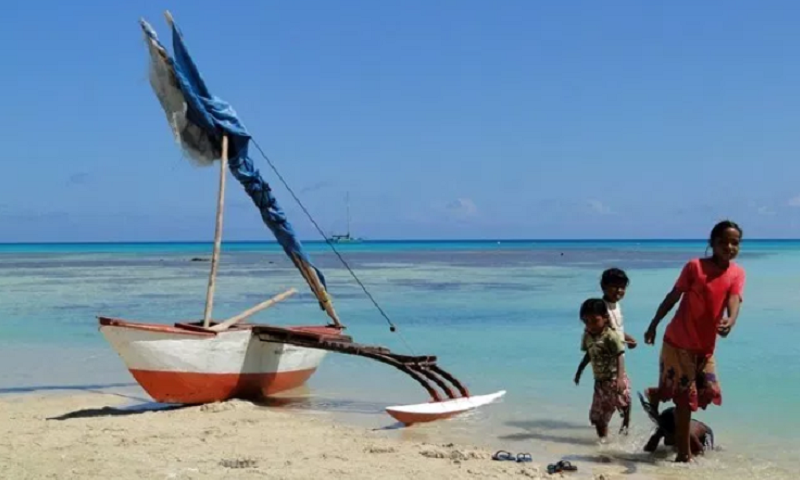 Kinder mit Boot am Strand auf den Marshallinseln