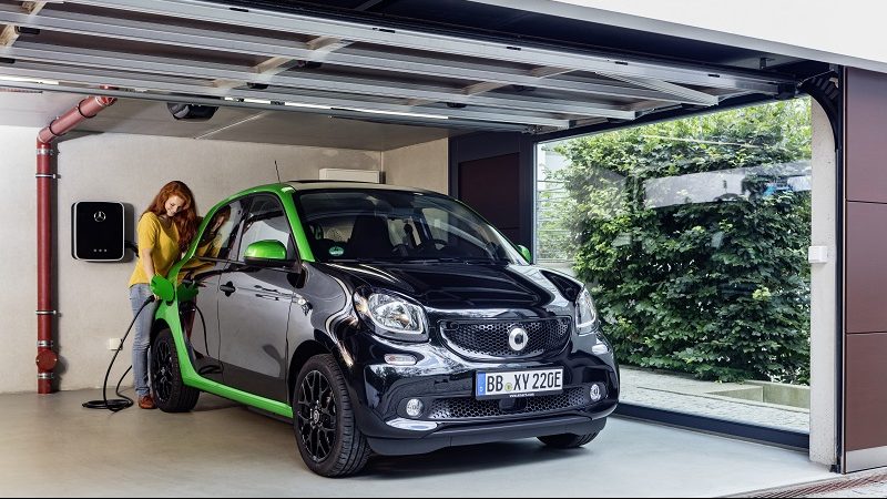 Eine Frau lädt Smart Forfour in der Garage