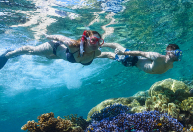 Mann und Frau mit Schnorcheln unter Wasser mit Korallenriff