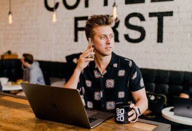 Mann, Laptop, Kaffee, Café, Telefonieren, Smartphone, erfolgreiche Telefonkonferenz