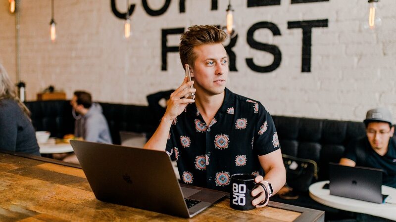 Mann, Laptop, Kaffee, Café, Telefonieren, Smartphone, erfolgreiche Telefonkonferenz