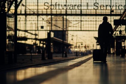 Ein Reisender am Bahnhof Frankfurt am Main in der Abendsonne.