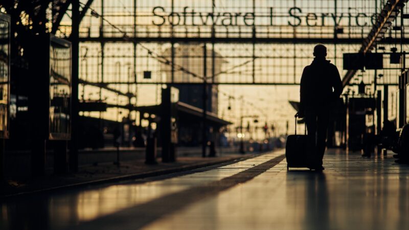 Ein Reisender am Bahnhof Frankfurt am Main in der Abendsonne.